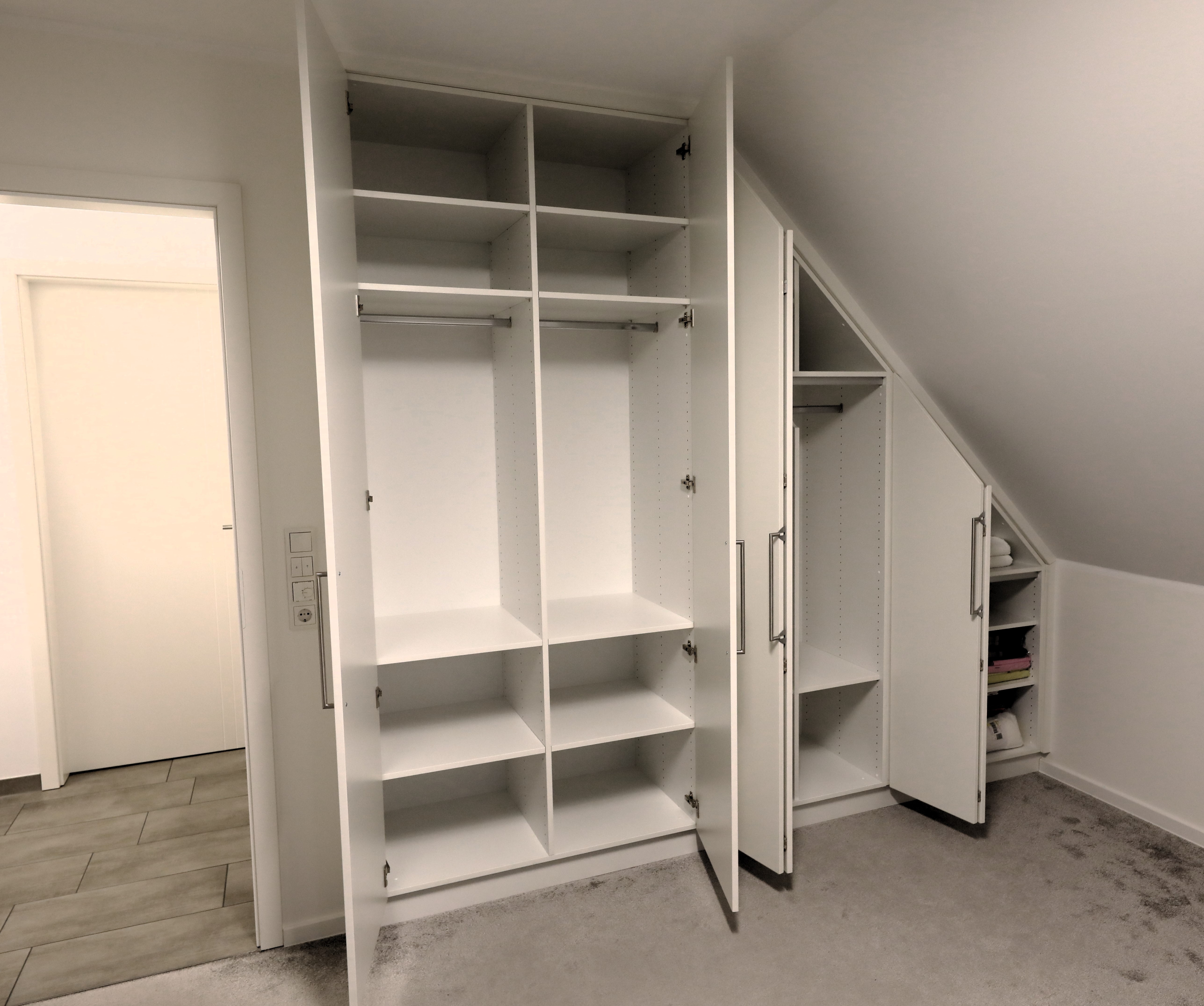 geöffnete Schrankwand mit Anpassungen an die Dachschräge