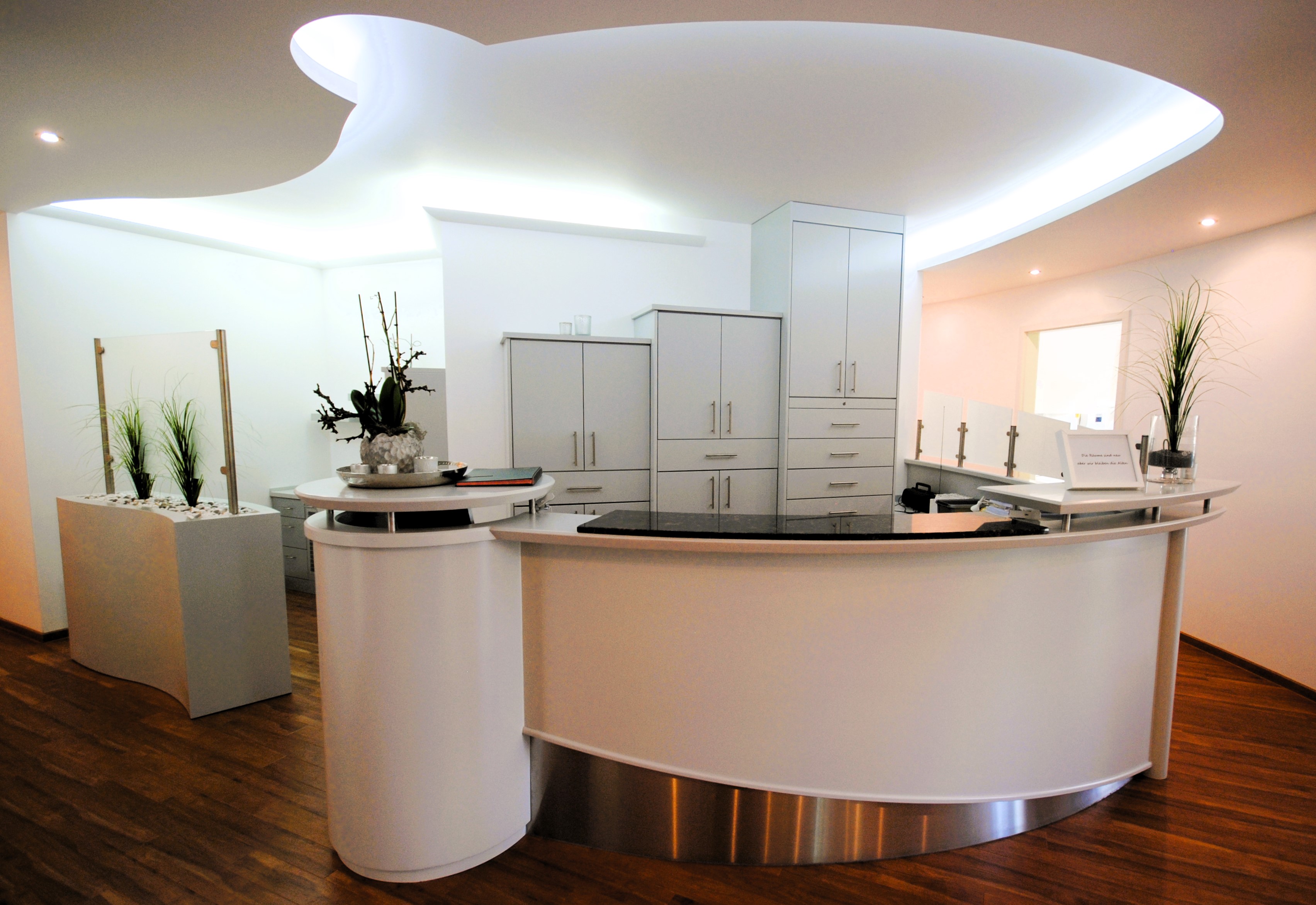 Arztpraxis mit schön gestalteten Ankunftsbereich und Tresen.