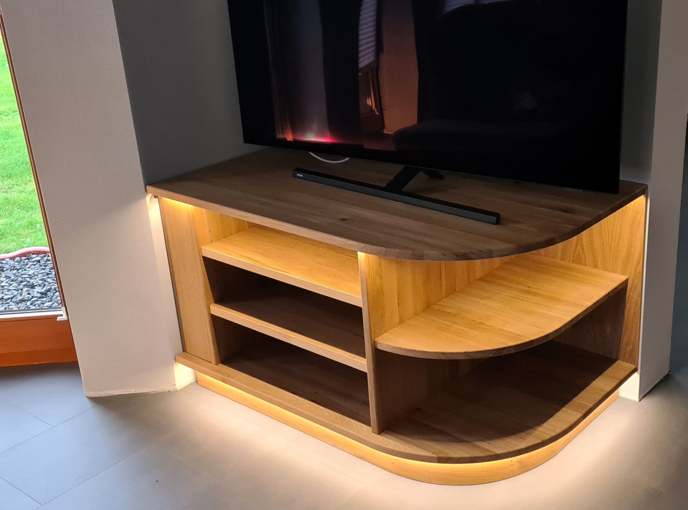 abgerundete TV-Bank im Eck mit indirekter Beleuchtung