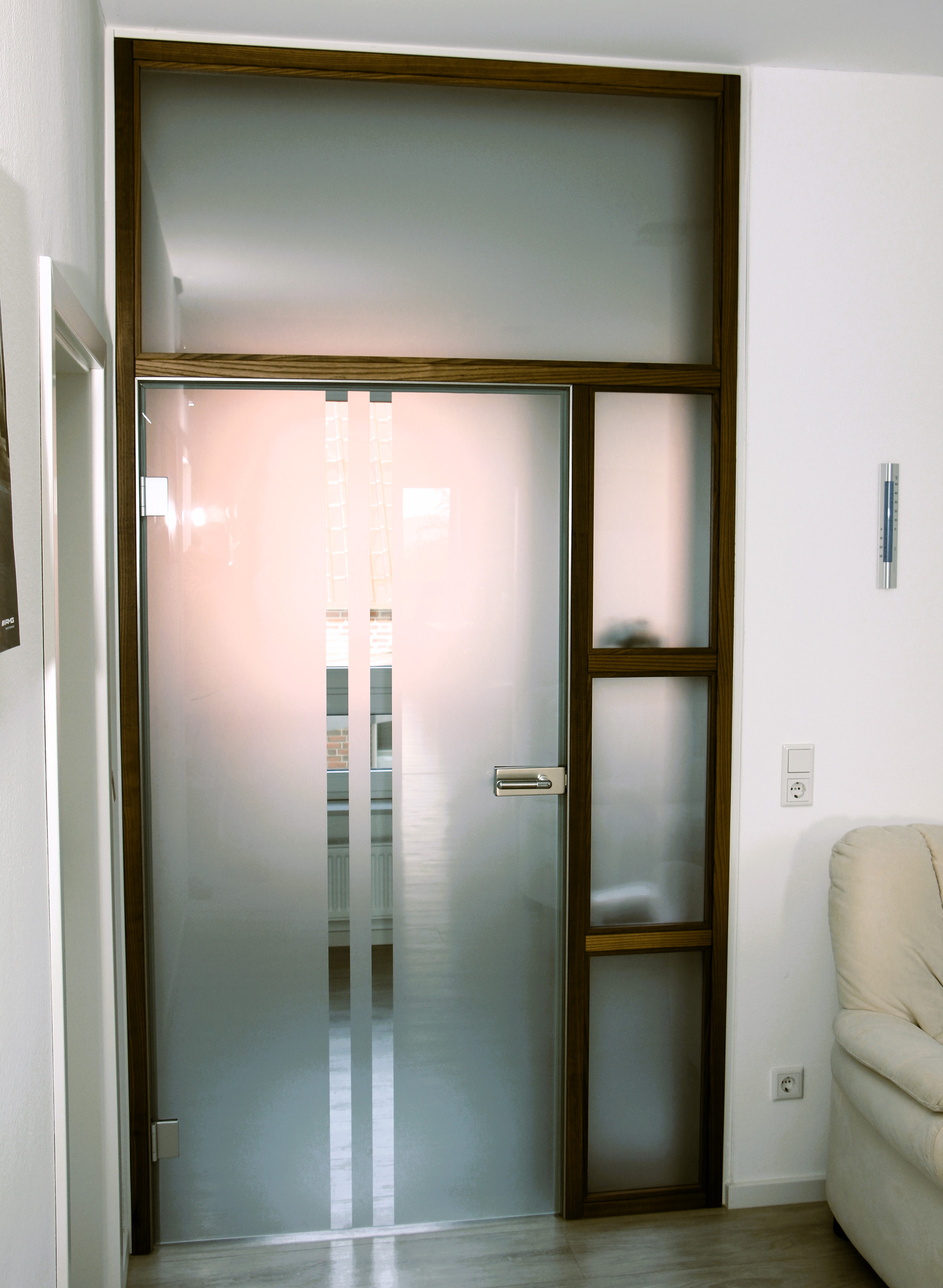 gläserner Windfänger mit dunklen Holzdetails