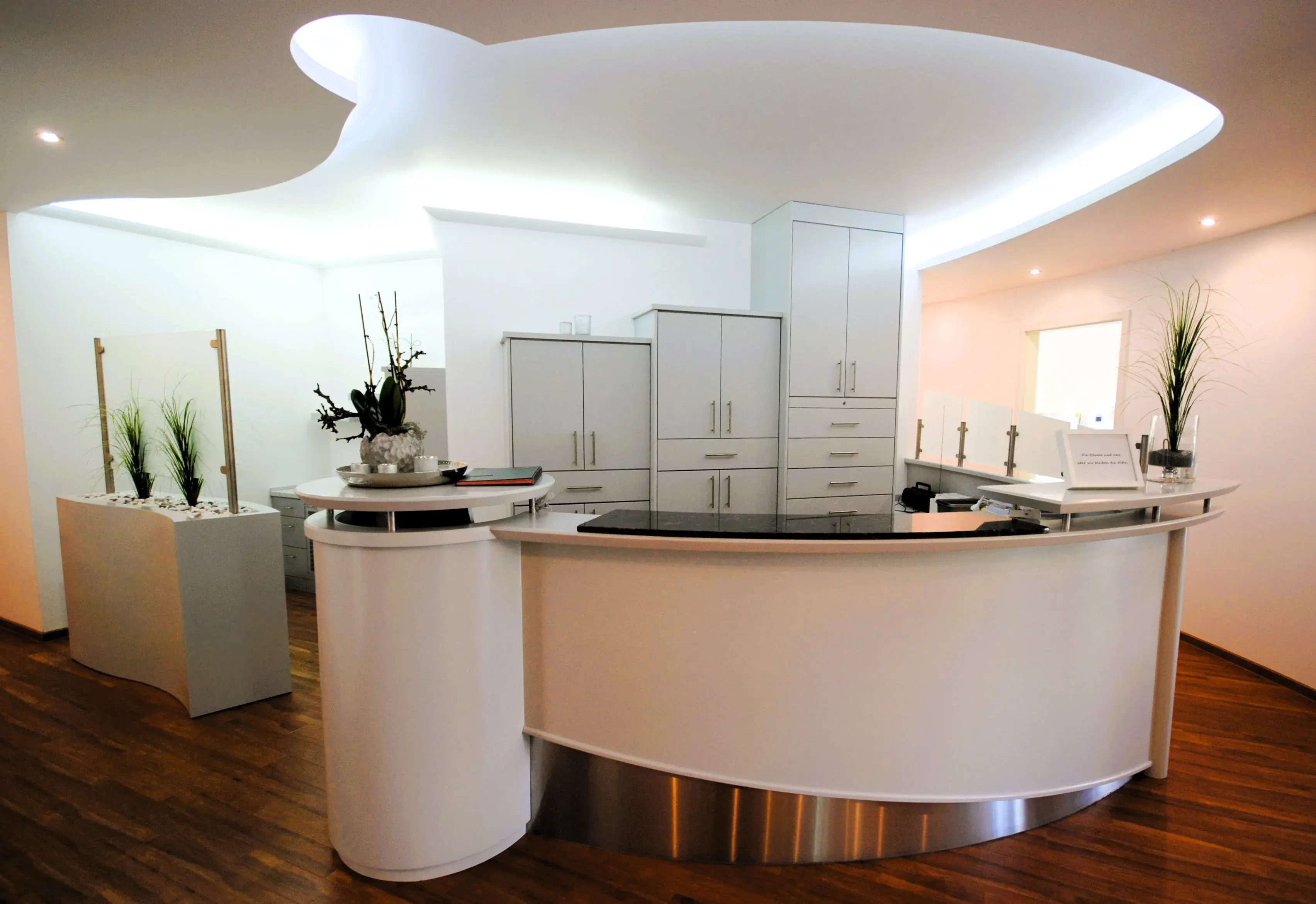 Arztpraxis mit schön gestalteten Ankunftsbereich und Tresen.